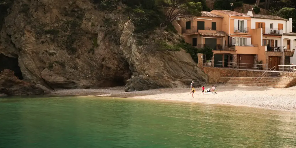 Crique, plage de sable et maisons au bord de l'eau