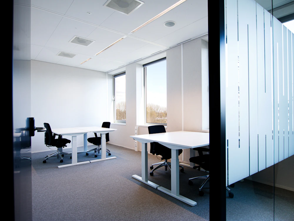Bureaux clairs derrière une cloison vitrée