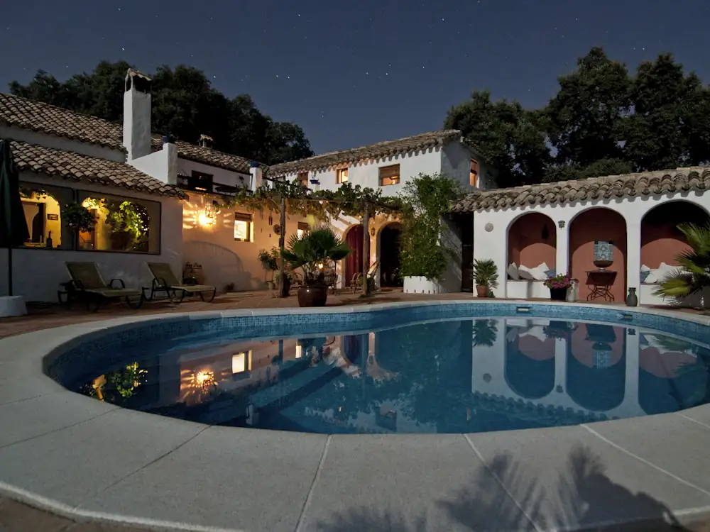Villa à arcades et piscine éclairée le soir